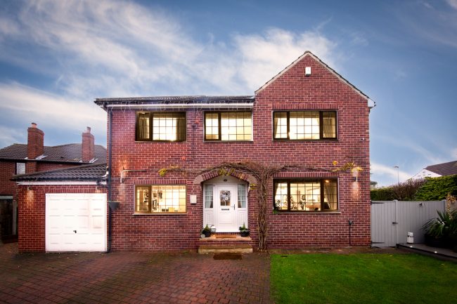 red-brick-house-lights red brick house with lights on showing garden and drive